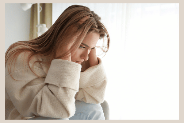 不安そうに頭を抱える若い女性