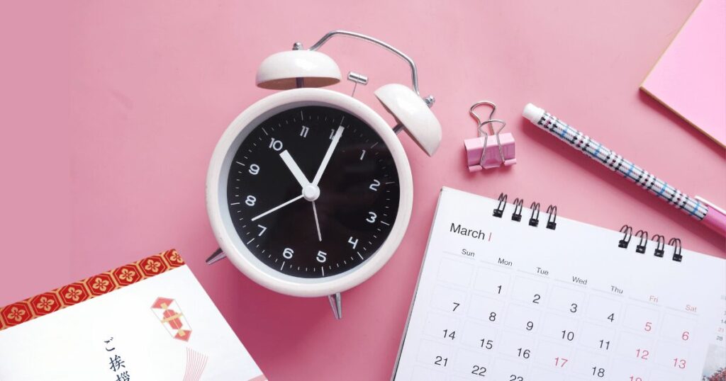 引越し挨拶が遅れた場合の期限を考えるイメージ。時計とカレンダー、挨拶用ののし袋が並んだ写真